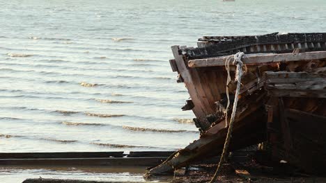 abandoned boat on shore with gentle waves