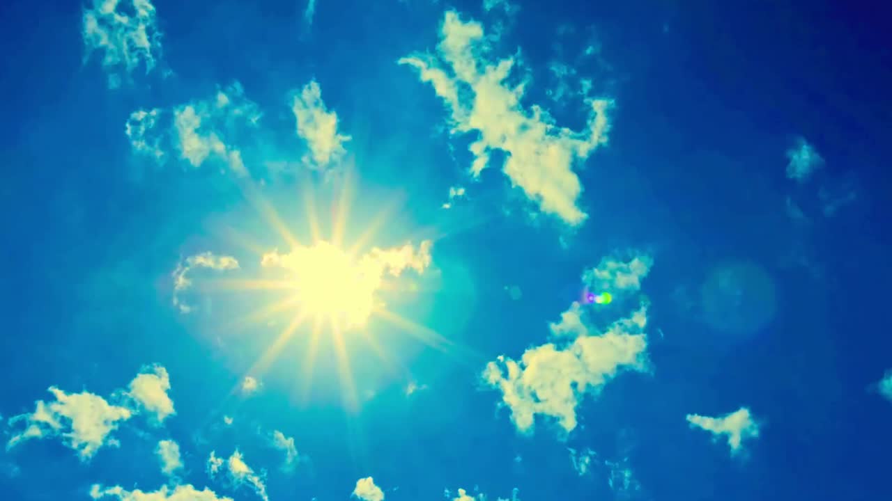 Sol brillante con destello de lente y nubes en movimiento en cielo azul