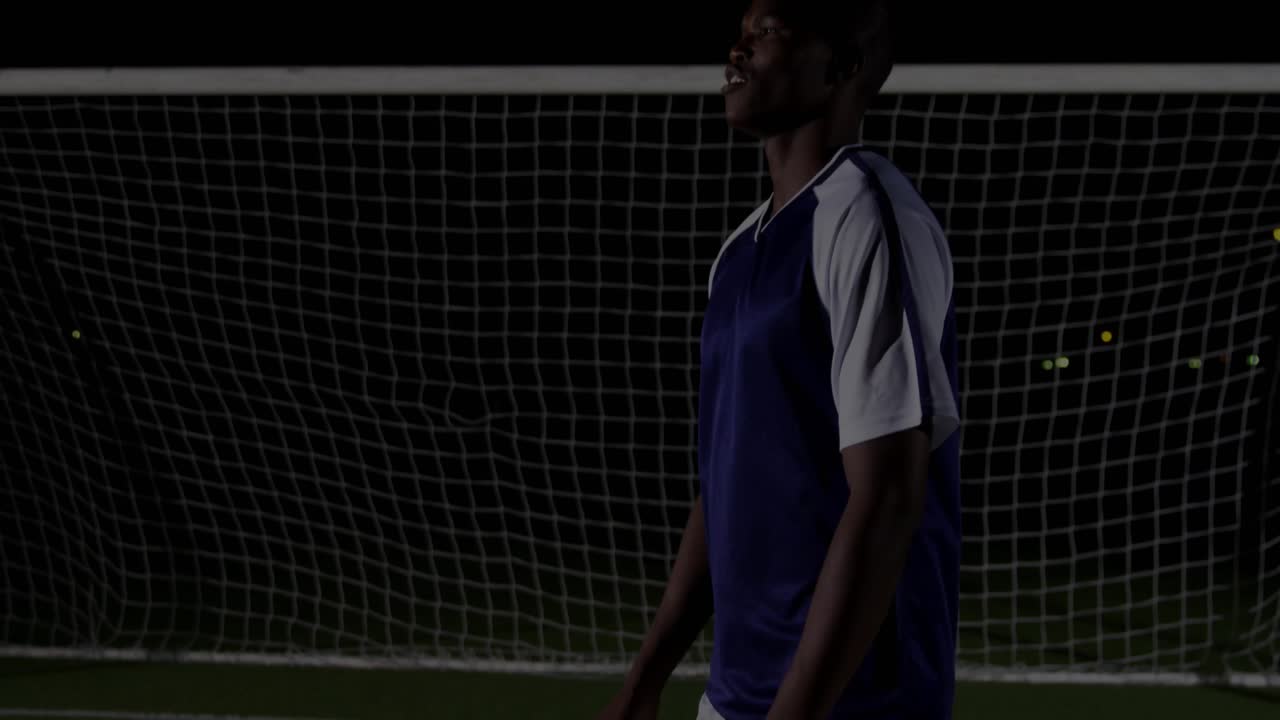 Calciatore che lancia il pallone dopo aver spostato lo sguardo, con un grafico finanziario che sale attraverso la rete di una porta illuminata a giorno.