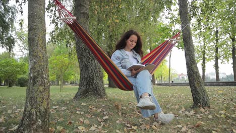 woman reading in a hammock in a park