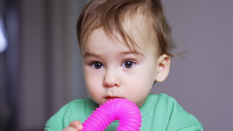 baby playing with pink toy