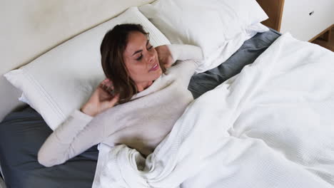 woman relaxing in cozy bed, enjoying peaceful morning at home
