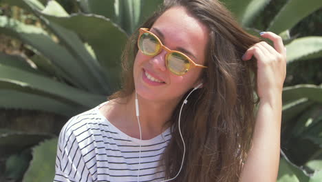 mujer con gafas de sol y auriculares sonriendo