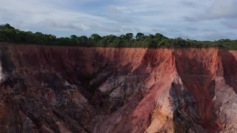 aerial - red cliffs at falesias do gunga beach, alagoas, brazil, rising reveal