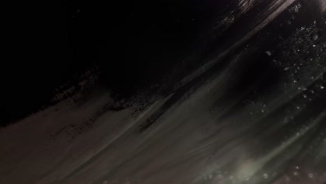 abstract close-up of dark, textured surface with light reflections and shadow play