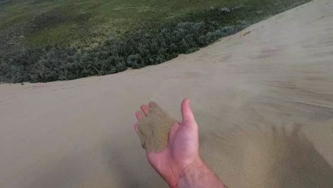 Cámara-Lenta---Una-Mano-Llena-De-Arena-Que-Se-Lleva-El-Viento