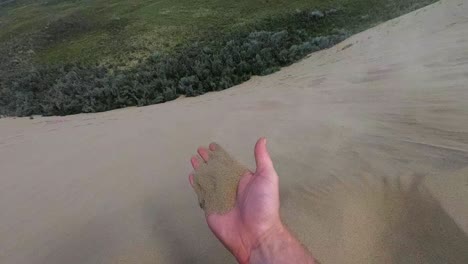 cámara lenta - una mano llena de arena que se lleva el viento