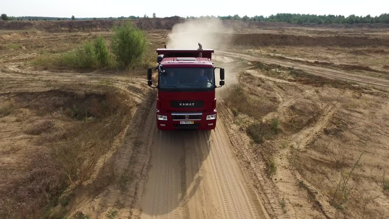 빨간색 덤프 트럭이 광산의  도로에서 운전
