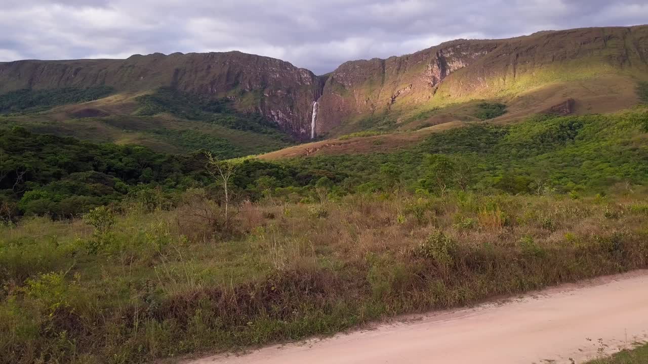 A scenic view of Serra da Canastra in Minas Gerais, Brazil, showing lush green hills and a waterfall