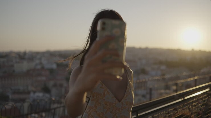 Woman Taking Selfie on Rooftop at Sunset