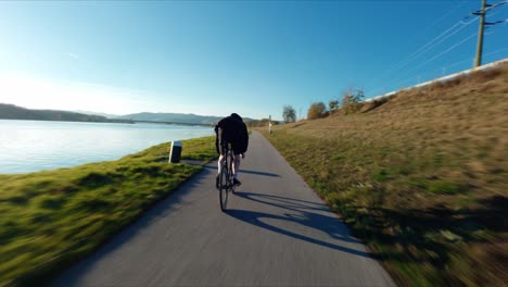 fpv siguiendo a jake the fixedgear biker junto al río danubio durante el soleado día de otoño