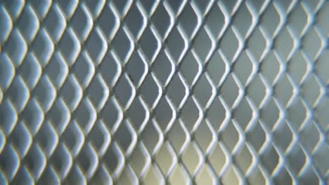 a hyper macro shot of a metal grid, steel pattern, iron industrial texture, aluminum material, super slow motion, full hd 120 fps, tilt up crane movement