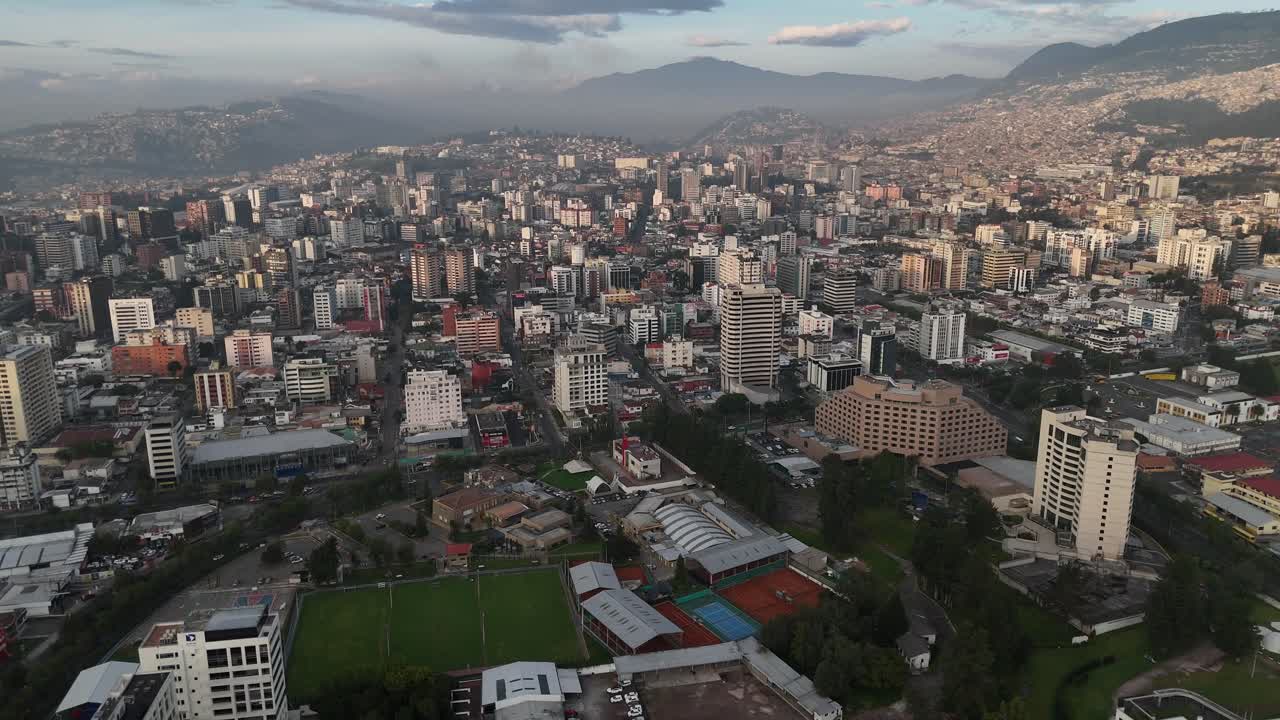 Aerial drone video view footage of Qutio early morning sunrise capital city of Ecuador La Carolina Park traffic Catedral Metropolitana de Quito south american skyline