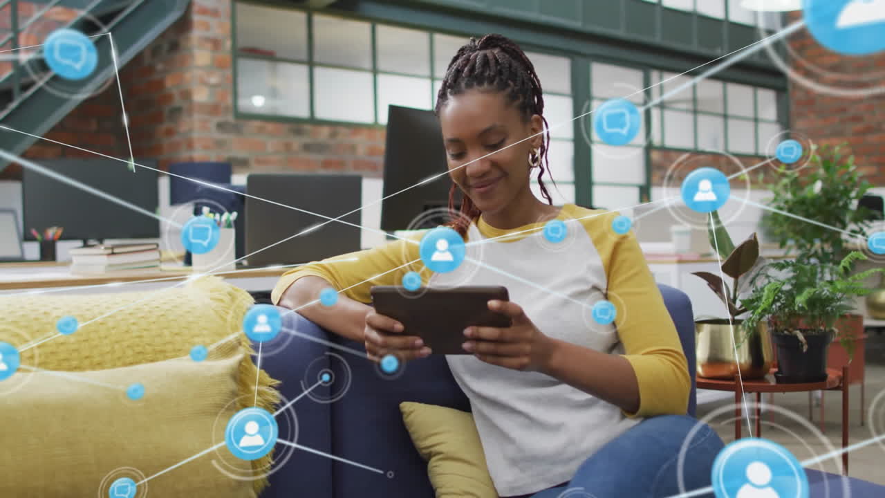 animación de la red de conexiones con íconos sobre mujer de negocios biracial usando tableta en la oficina