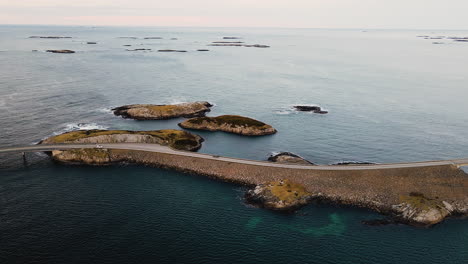 norwegian coastline at atlantic ocean road with traveling cars passing by islands