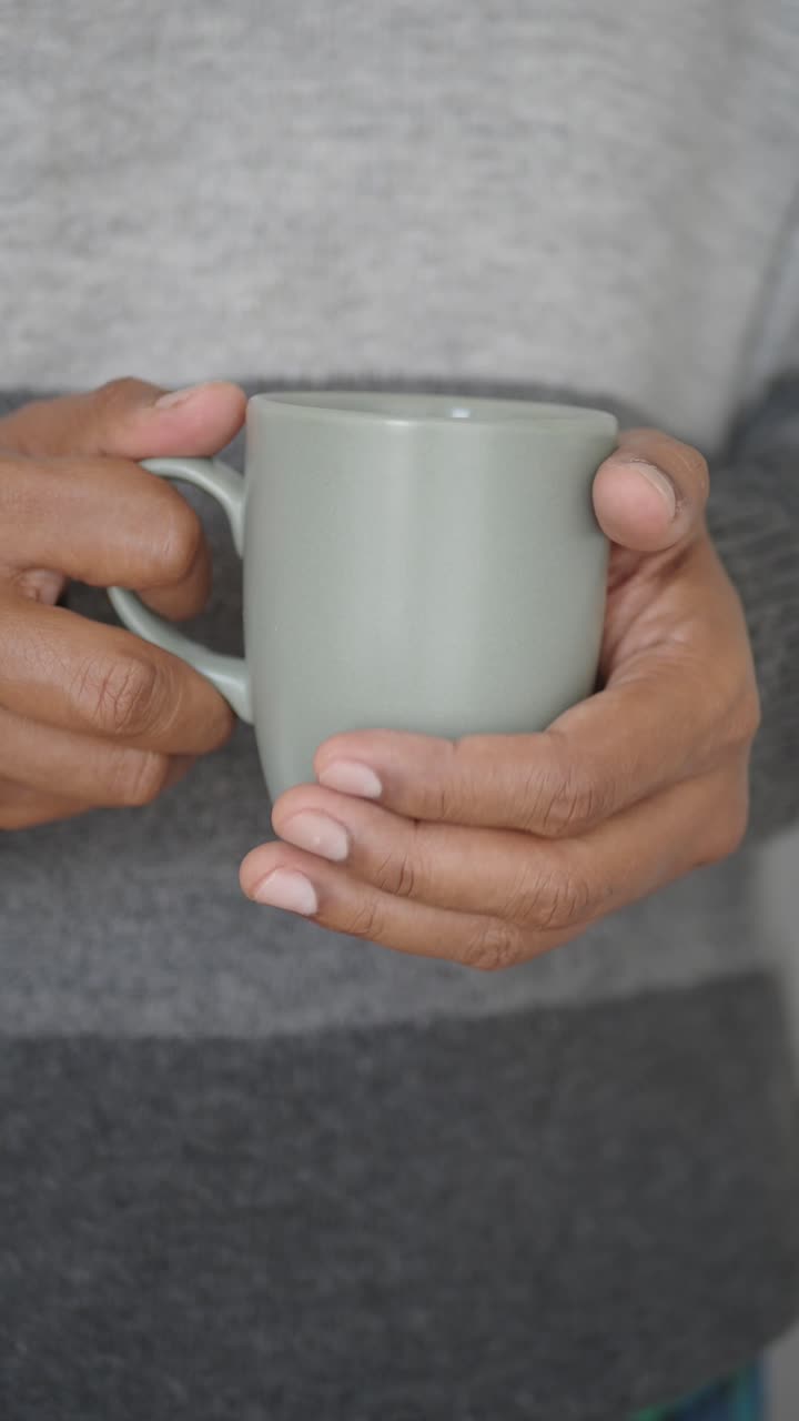 Primo piano di mani che tengono una tazza calda