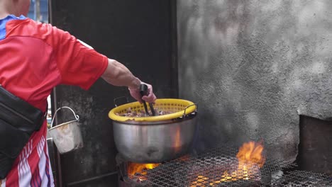 vendedor ambulante de comida cocinando caracoles