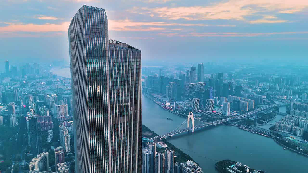 Aerial view of Guangzhou city center at sunset. The modern skyline with a towering skyscraper and the iconic bridge over the Pearl River, blends urban development with scenic beauty. China.