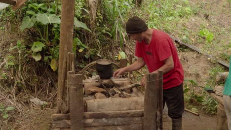 hombre construyendo una estufa de leña para cocinar