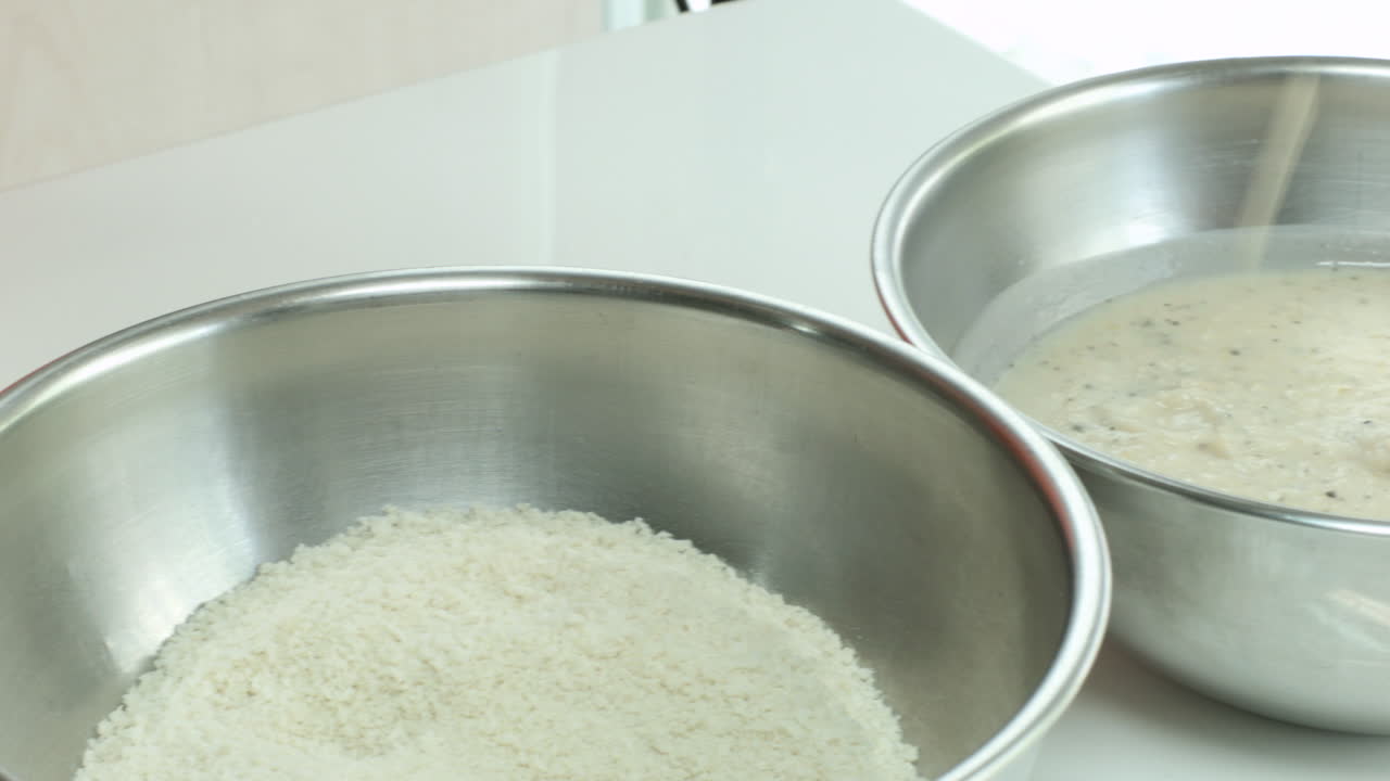 닭고기를 소스에 담그고 빵가루를 입히는 중