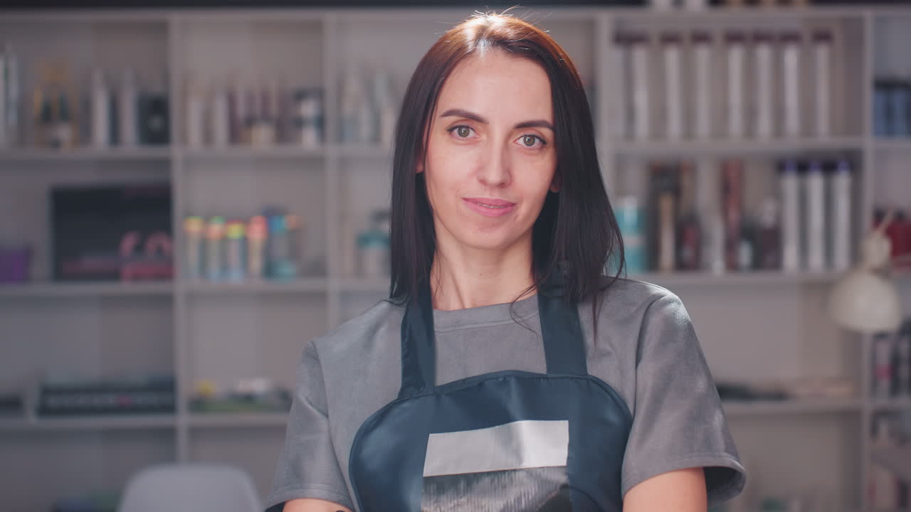 стилист, оказывающий помощь, приветливый парикмахер с организованными инструментами, профессиональный парикмахер, радостно обслуживающий клиентов, оживленная атмосфера салона с услужливым стилистом и ярким освещением