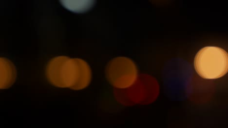 hermoso bokeh brillante en el fondo oscuro borroso por la noche. el redondo bokeh colorido brilla de las luces de los coches en la calle de la ciudad. fuera de foco con borroso. luces de la ciudad sin enfoque. bokeh de tráfico. concepto abstracto