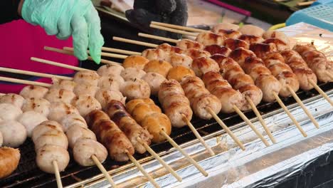 grilled sausage skewers at a thai street food stall