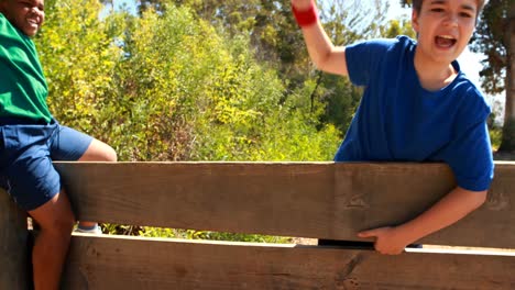 Kinder-Jubeln-Während-Des-Hindernisparcours-An-Einer-Holzwand