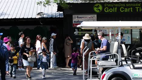 people gather near golf cart ticket area