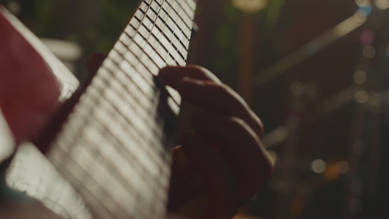 Close-up of hands playing an electric guitar fretboard