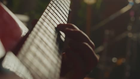 close-up of hands playing an electric guitar fretboard