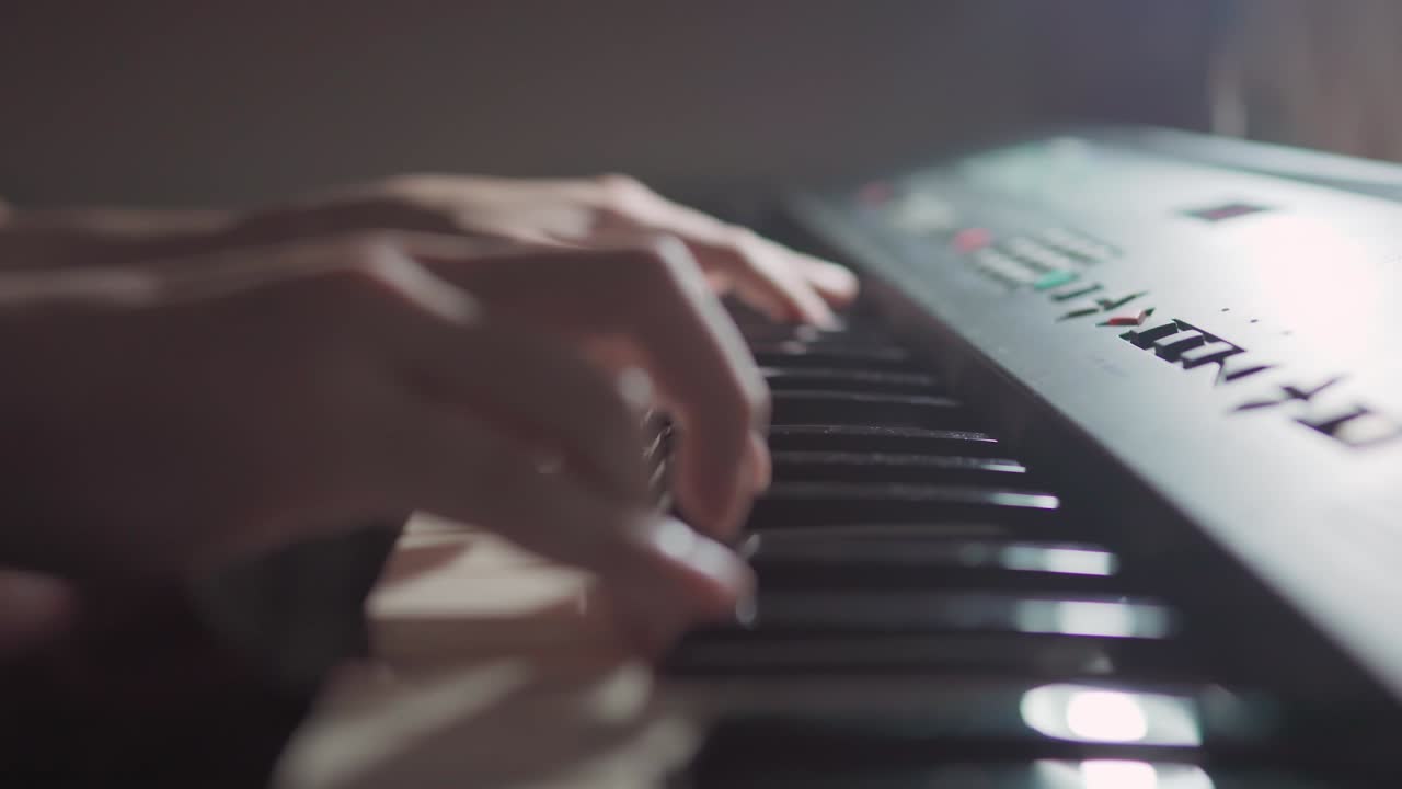 vista lateral de la escena de cerca de las manos de los estudiantes tocando practicando la improvisación del teclado por la noche para una clase de piano de jazz en línea por la noche durante la pandemia de covid-19 coronavirus, distanciamiento social.