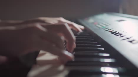 close up scene side view of student hands playing practicing improvising keyboard at night for a jazz piano online class at night during the pandemic of covid-19 coronavirus, social distancing.