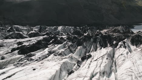 low aerial tracking shot over cracks, crevasses in surface of iceland glacier