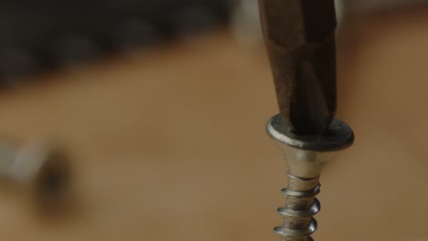 macro view of drill bit trying to screw in slanted screw with electric screwdriver