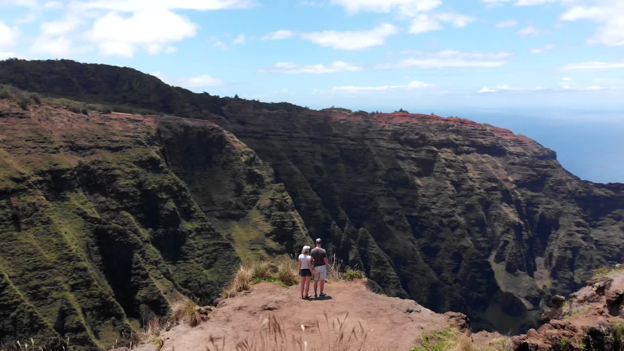 Aerial Orbit of Couple on the Awa'awapuhi Trail in Hawaii, with Beautiful Mountains and Ridge Lines.