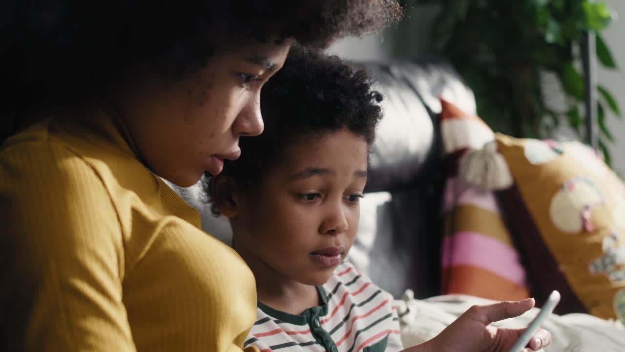 Two children browsing digital tablet in the living room