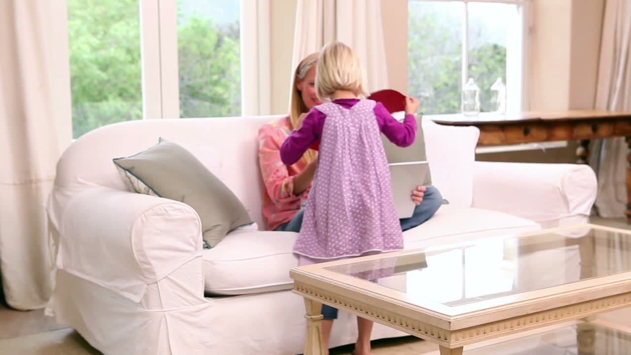 귀여운 어린 소녀가 어머니에게 심장 카드를 주고 있다