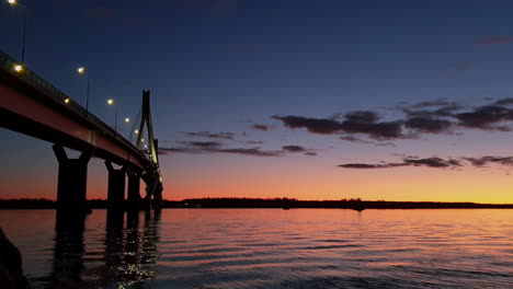 Low-static-view-of-bridge-over-water-at-beautiful-colorful-sunset