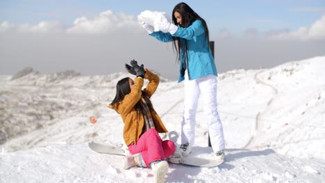 Two-young-female-friends-playing-in-the-snow