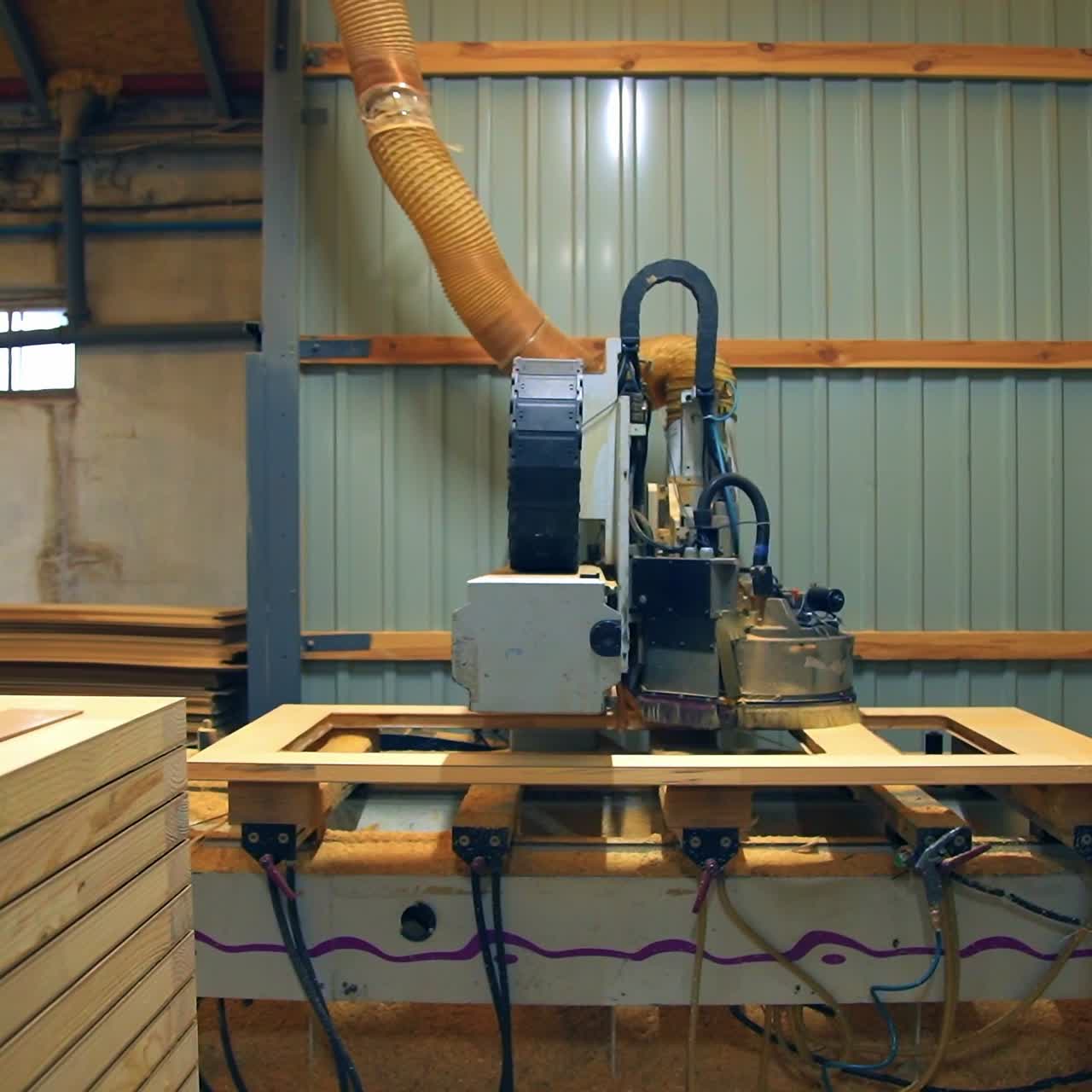 Plant for wooden doors manufacturing. Complicated equipment moving over the door to make it smooth