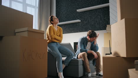 exhausted spouses moving apartment. tired married couple sitting couch new home.