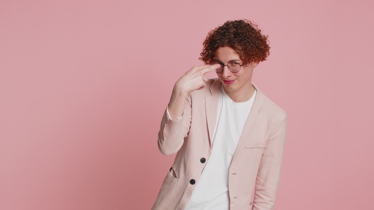 젊은이가 눈을 가리키고 카메라를 보여 주고, 나는 당신을 지시하고, 스파이하고, 누군가를 지켜보고 있습니다.