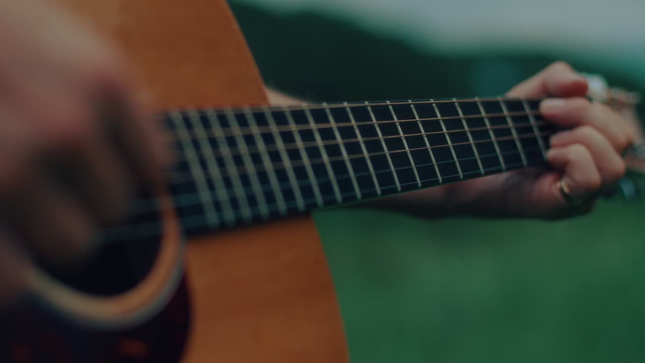 Close up of hands playing an acoustic guitar