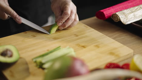 person slicing fresh avocado on a cutting board