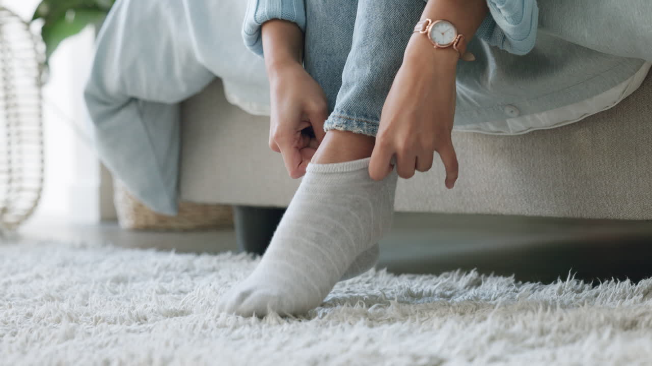 mujer, manos o pies en calcetines de invierno en la casa