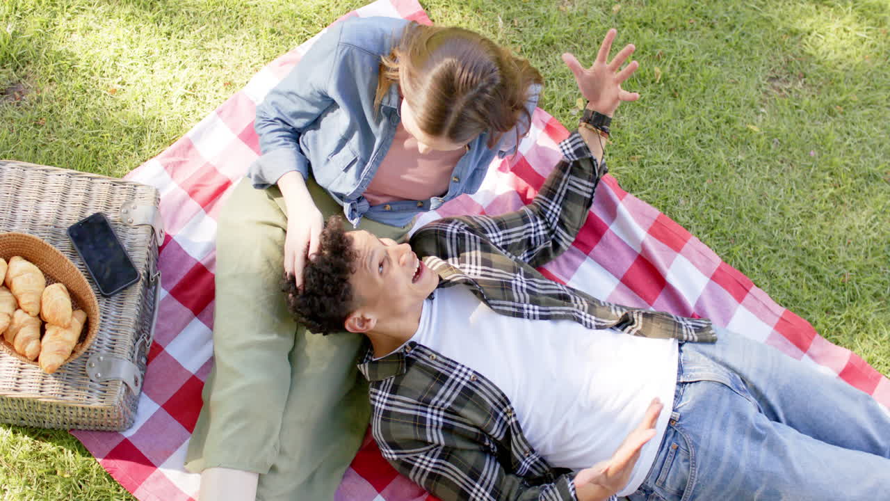 다양한 행복 한 커플 이 슬로 모션 으로 빛 이 있는 정원 에서 피크닉 을 하고 있다