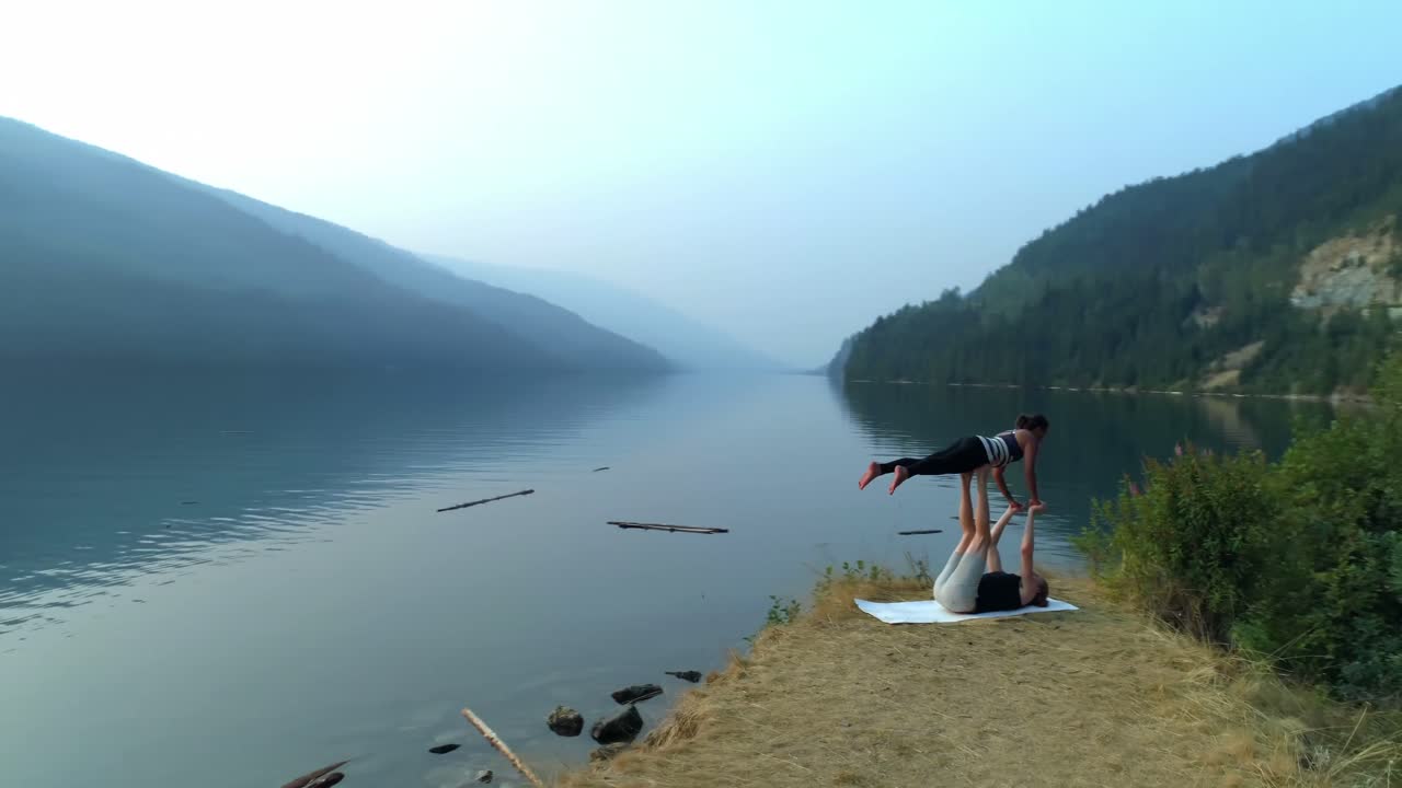 두 명의 여성이 아크로요가 4k를 연습합니다.