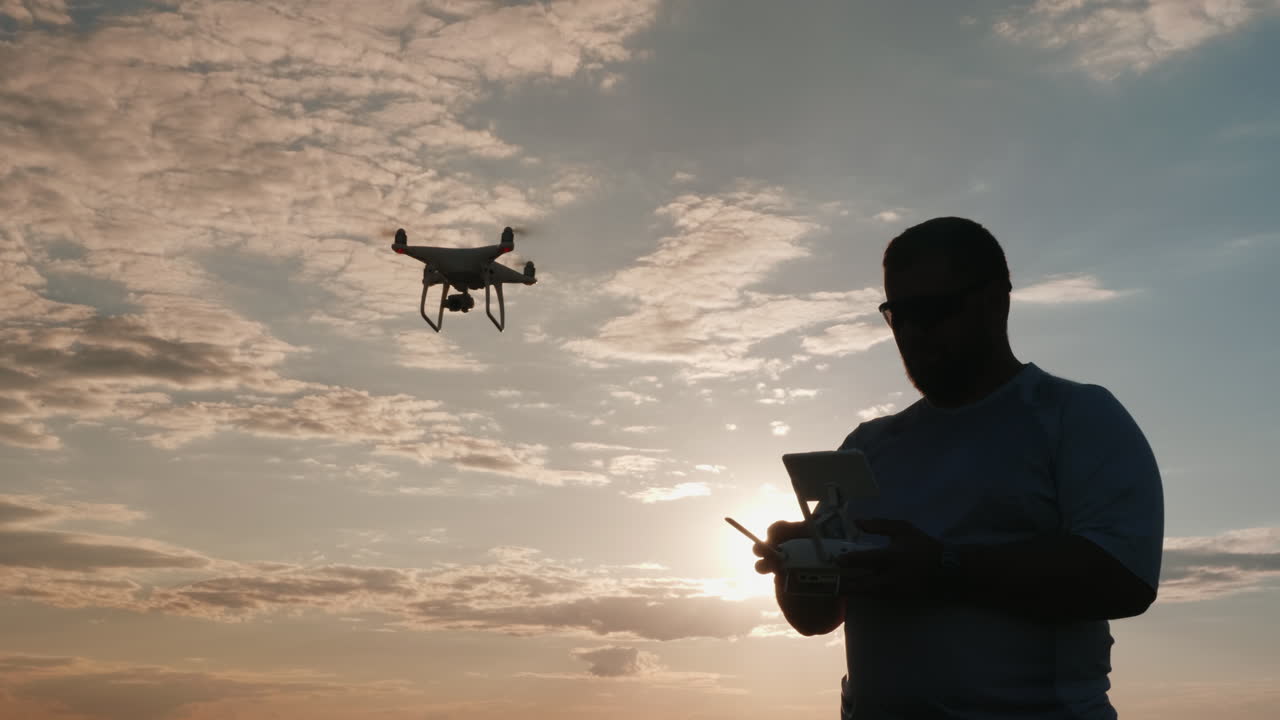 el hombre controla el dron mientras la cámara lo sigue 1
