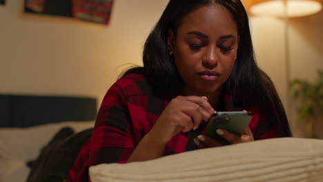 woman using smartphone in bedroom at night